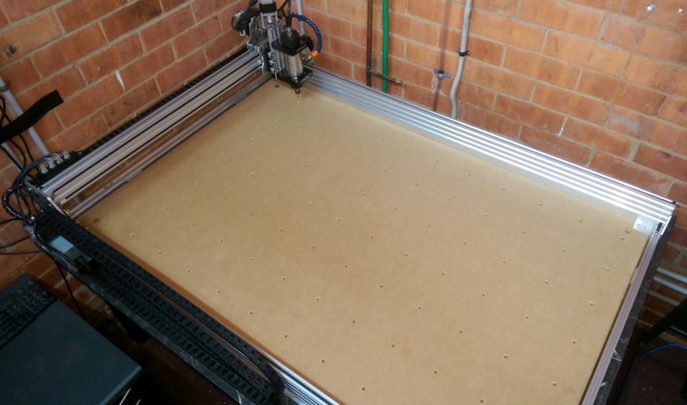 Photo of CNC bed with holes for inserts